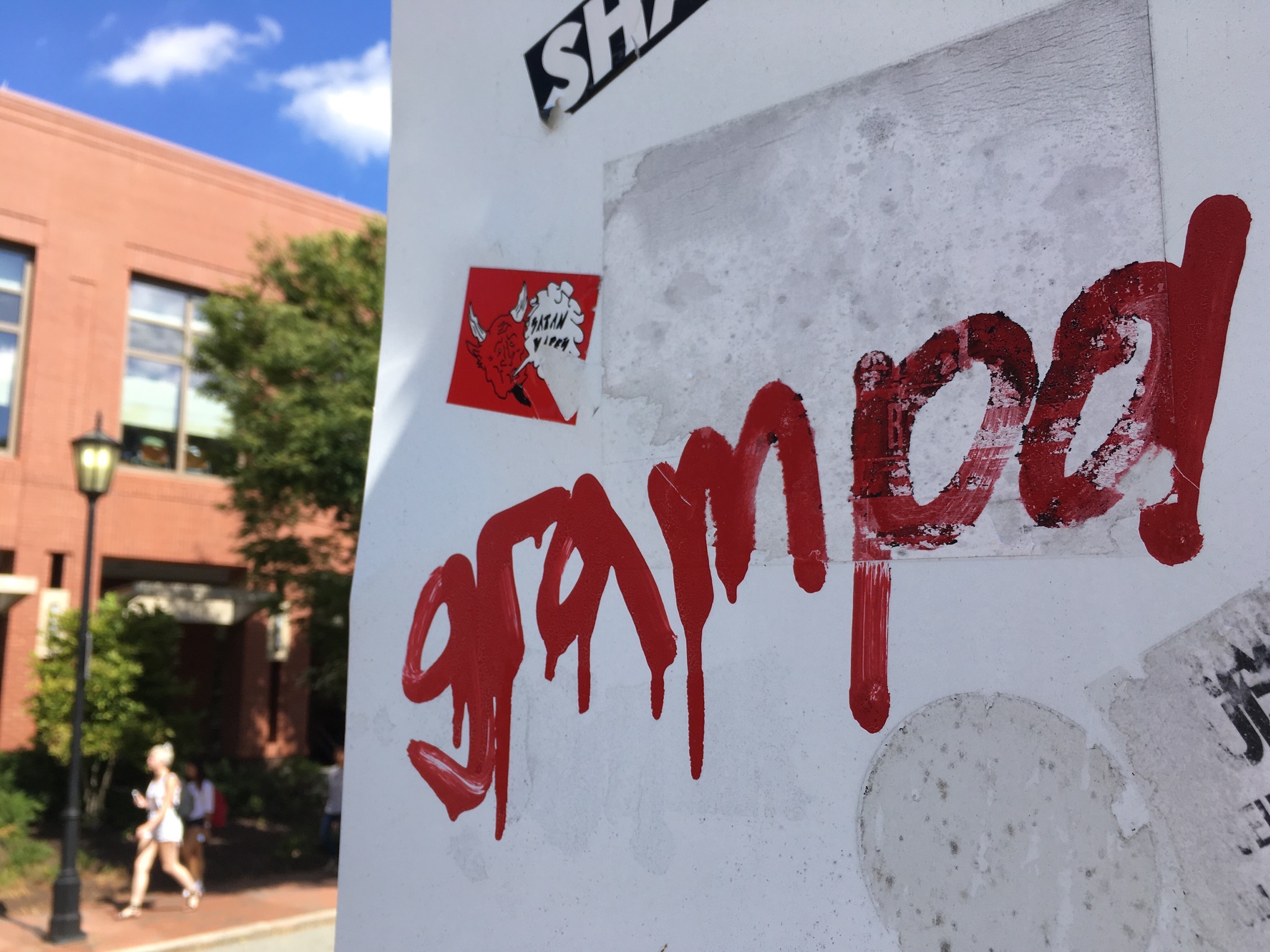 red paint on the back of a street sign spelling out the word "grandpa"